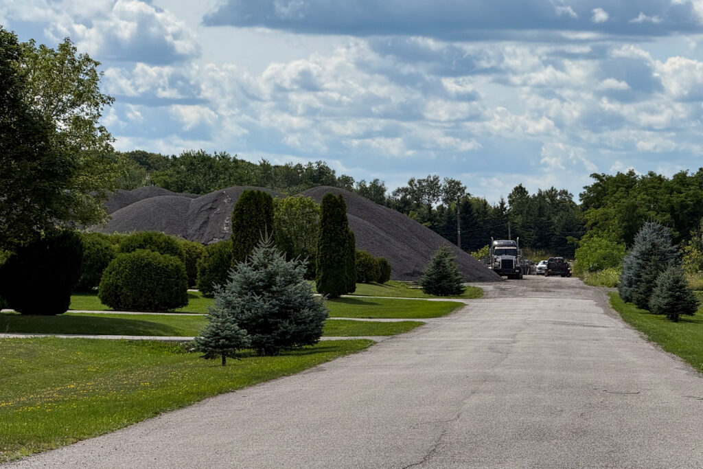 A photograph showing large stockpiles at the rear of 14004 Woodbine in Vandorf. 
